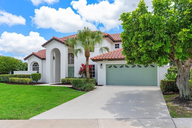 mediterranean / spanish-style house with a tiled roof, stucco siding, a garage, and driveway