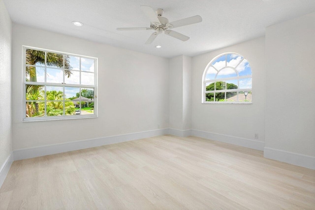 empty room with wood finished floors, baseboards, ceiling fan, and recessed lighting