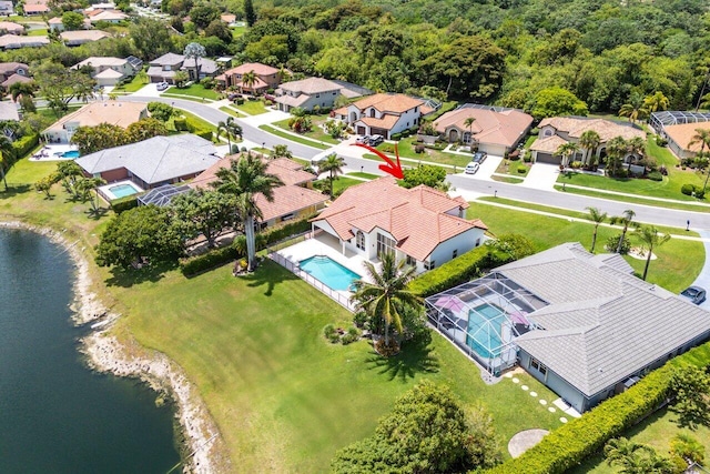 aerial perspective of suburban area featuring a large body of water and a pool area