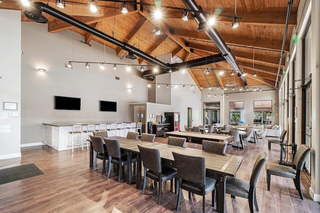 dining area with high vaulted ceiling, wood ceiling, baseboards, wood finished floors, and beamed ceiling