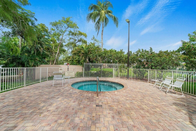 view of swimming pool featuring fence, a community hot tub, and a patio area