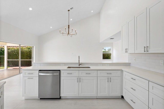 kitchen featuring stainless steel dishwasher, a sink, high vaulted ceiling, a chandelier, and plenty of natural light