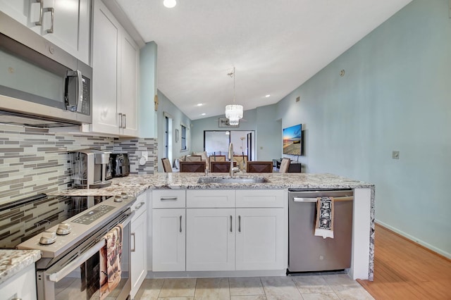 6235 Kings Gate Cir Unit C, Delray Beach, FL 33484 - kitchen with appliances with stainless steel finishes, a sink, tasteful backsplash, a peninsula, and light stone counters