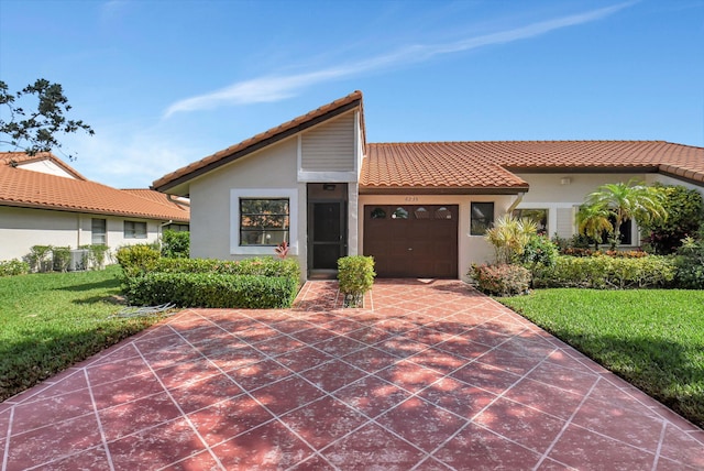 6235 Kings Gate Cir Unit C, Delray Beach, FL 33484 - view of front of house with a garage, stucco siding, a tile roof, a front yard, and driveway