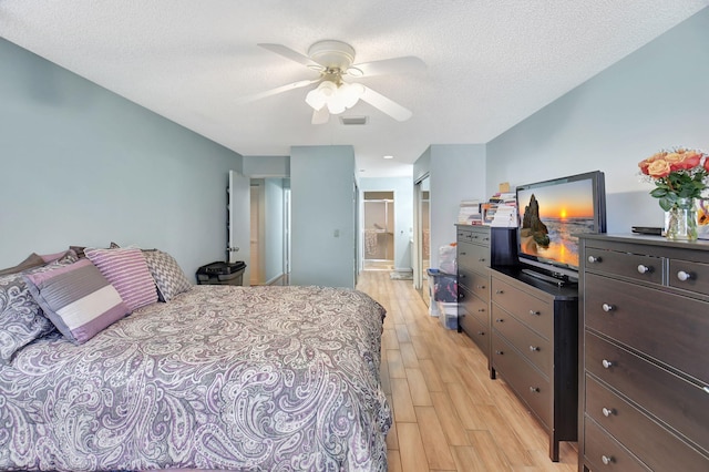 6235 Kings Gate Cir Unit C, Delray Beach, FL 33484 - bedroom with light wood finished floors, ensuite bathroom, ceiling fan, and a textured ceiling