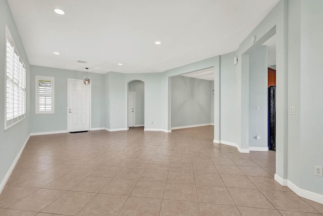 1500 Mariner Bay Blvd Unit 1500, Fort Pierce, FL 34949 - unfurnished room featuring light tile patterned floors, arched walkways, recessed lighting, and baseboards