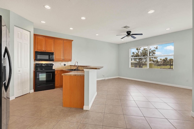 1500 Mariner Bay Blvd Unit 1500, Fort Pierce, FL 34949 - kitchen with black appliances, a sink, a peninsula, light tile patterned floors, and recessed lighting
