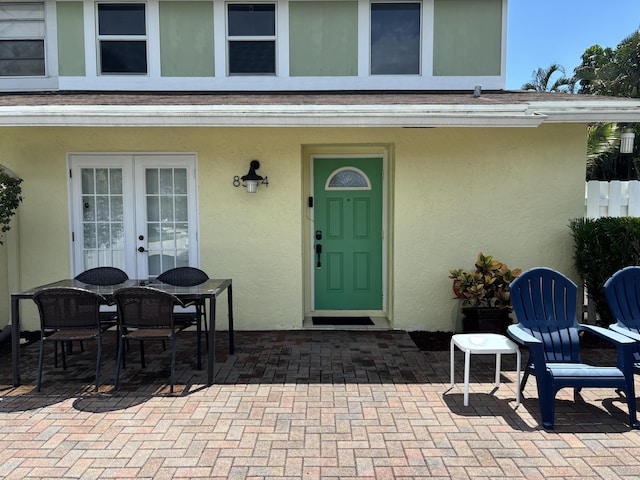 property entrance featuring stucco siding, french doors, and a patio area
