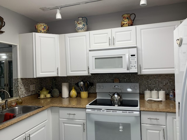 kitchen featuring white appliances, tasteful backsplash, white cabinets, and a sink