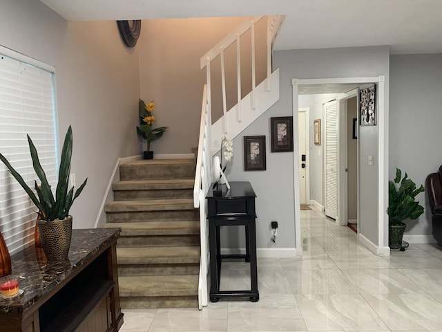 staircase with marble finish flooring and baseboards