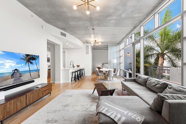 living area featuring a notable chandelier, visible vents, and light wood-style floors