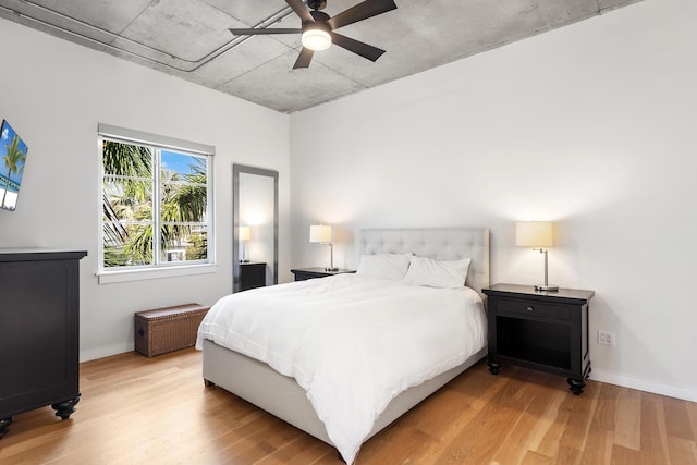 bedroom with baseboards, light wood-style floors, and a ceiling fan