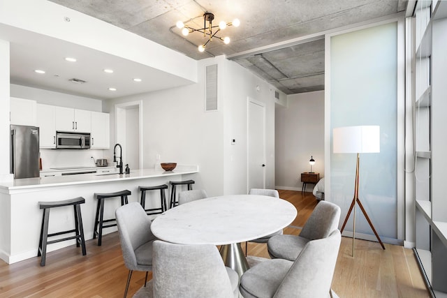 dining area featuring recessed lighting, light wood finished floors, a chandelier, and visible vents