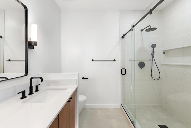 bathroom with baseboards, toilet, a shower stall, tile patterned floors, and vanity