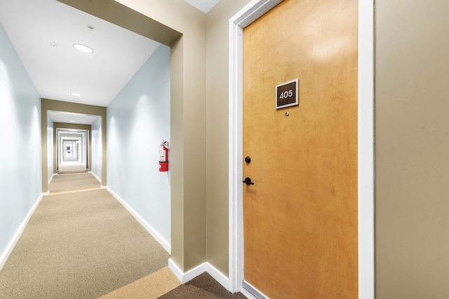 hall with carpet, baseboards, and recessed lighting