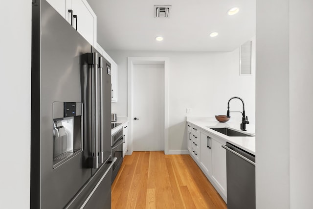 kitchen featuring a sink, white cabinetry, visible vents, and appliances with stainless steel finishes