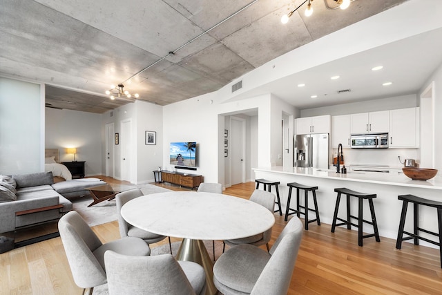 dining room with light wood finished floors, visible vents, and recessed lighting