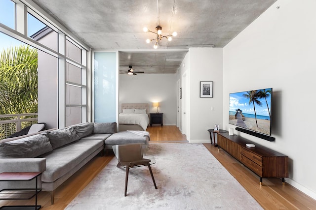 living area with wood finished floors, baseboards, and a healthy amount of sunlight