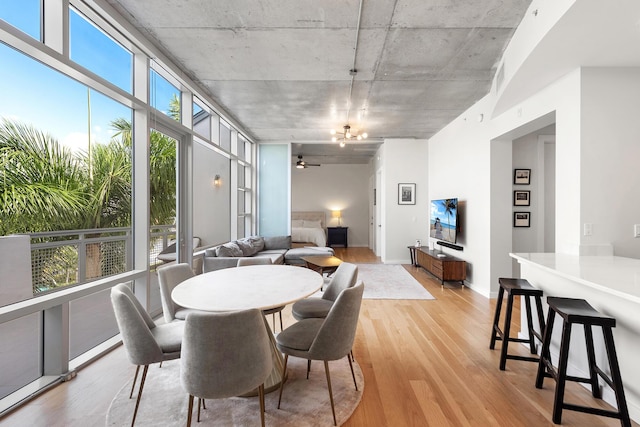 dining room featuring a ceiling fan, light wood-style floors, visible vents, and baseboards