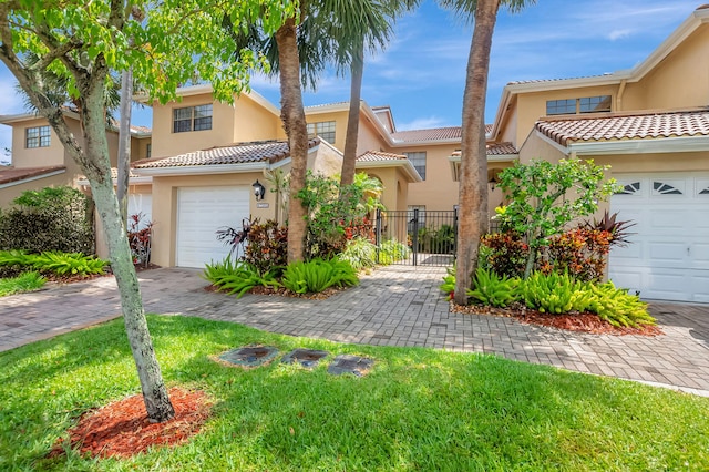 townhome / multi-family property featuring a tiled roof, stucco siding, fence, and driveway