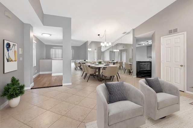 living room with baseboards, light tile patterned flooring, and a chandelier