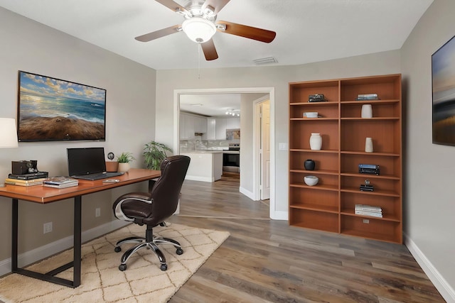 home office featuring dark wood-style flooring, baseboards, and ceiling fan