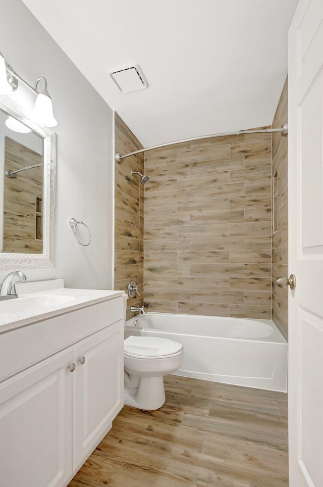 full bath featuring bathtub / shower combination, toilet, vanity, and wood finished floors