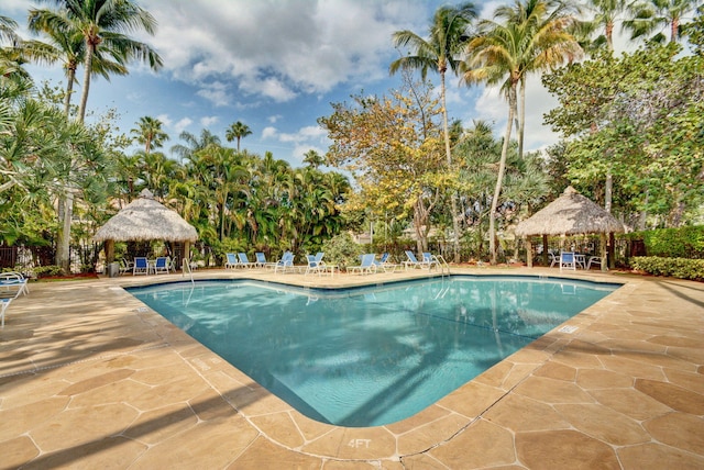 community pool with a gazebo, a patio area, and fence