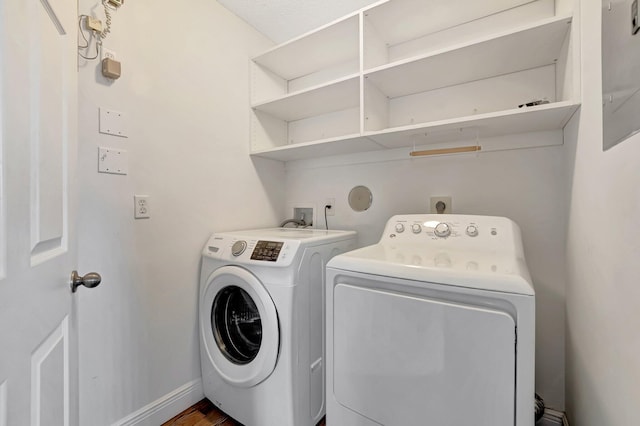 washroom with washing machine and clothes dryer and baseboards