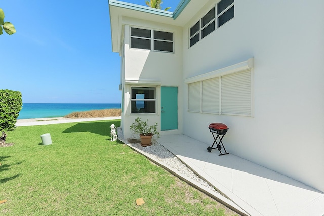 1470 S Ocean Blvd Unit 1201, Lauderdale By The Sea, FL 33062 - view of exterior entry featuring a water view, a yard, and stucco siding