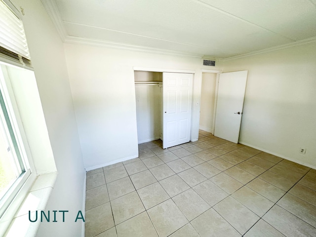 817 Lighthouse Dr Unit A, B, C, D, North Palm Beach, FL 33408 - unfurnished bedroom featuring ornamental molding, light tile patterned flooring, a closet, and baseboards