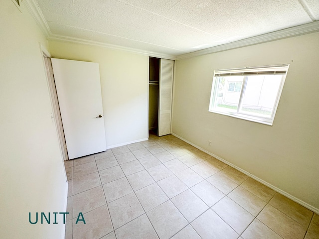 817 Lighthouse Dr Unit A, B, C, D, North Palm Beach, FL 33408 - unfurnished bedroom featuring crown molding, light tile patterned flooring, a textured ceiling, a closet, and baseboards