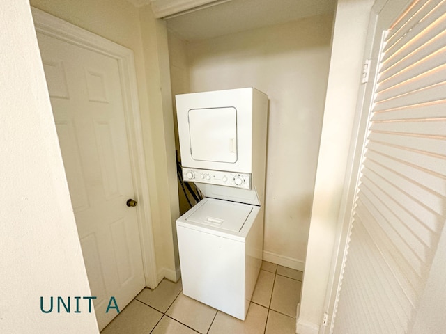 817 Lighthouse Dr Unit A, B, C, D, North Palm Beach, FL 33408 - washroom featuring stacked washer / dryer, light tile patterned flooring, and baseboards