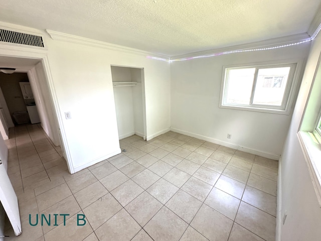 817 Lighthouse Dr Unit A, B, C, D, North Palm Beach, FL 33408 - unfurnished bedroom with crown molding, a textured ceiling, light tile patterned floors, a closet, and baseboards