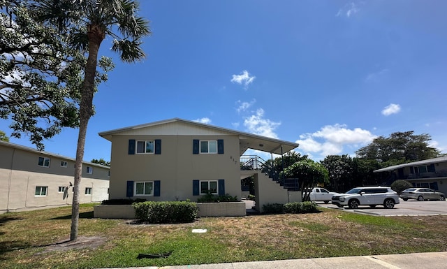 817 Lighthouse Dr Unit A, B, C, D, North Palm Beach, FL 33408 - view of home's exterior with stairs, a yard, and stucco siding