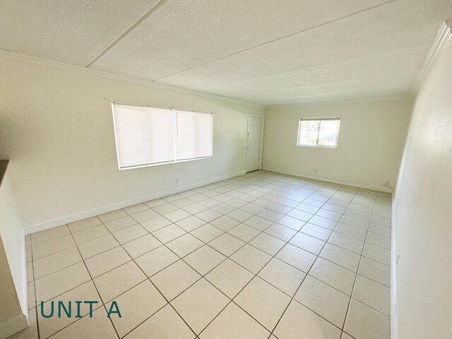 817 Lighthouse Dr Unit A, B, C, D, North Palm Beach, FL 33408 - empty room with ornamental molding, light tile patterned flooring, and baseboards