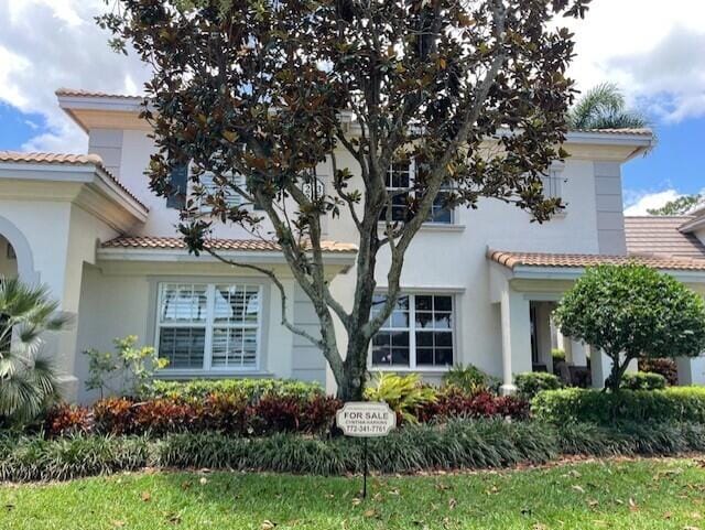 203 Evergrene Pkwy, Palm Beach Gardens, FL 33410 - view of property exterior with a tiled roof and stucco siding