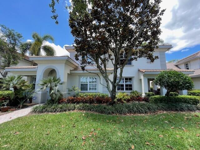 203 Evergrene Pkwy, Palm Beach Gardens, FL 33410 - mediterranean / spanish home featuring a front lawn, stucco siding, and a tile roof