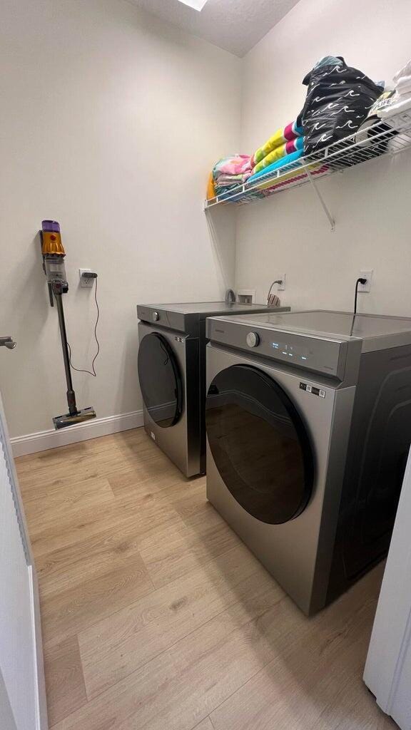 203 Evergrene Pkwy, Palm Beach Gardens, FL 33410 - washroom with light wood-style flooring, separate washer and dryer, and baseboards