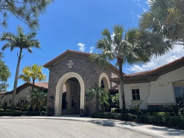 203 Evergrene Pkwy, Palm Beach Gardens, FL 33410 - view of front facade with a tiled roof, stucco siding, and stone siding