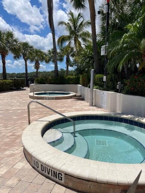 203 Evergrene Pkwy, Palm Beach Gardens, FL 33410 - view of swimming pool featuring a community hot tub, a swimming pool, and a patio