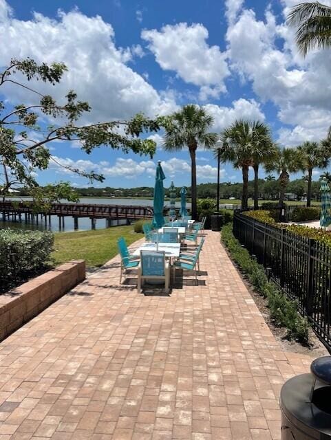 203 Evergrene Pkwy, Palm Beach Gardens, FL 33410 - view of patio / terrace with fence and a water view