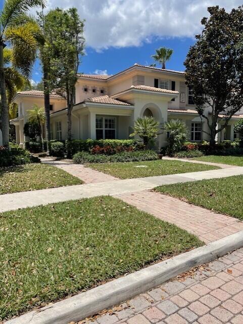203 Evergrene Pkwy, Palm Beach Gardens, FL 33410 - mediterranean / spanish-style home with a tiled roof, stucco siding, and a front yard