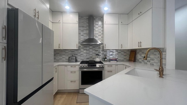 203 Evergrene Pkwy, Palm Beach Gardens, FL 33410 - kitchen with stainless steel appliances, wall chimney exhaust hood, a sink, tasteful backsplash, and white cabinetry