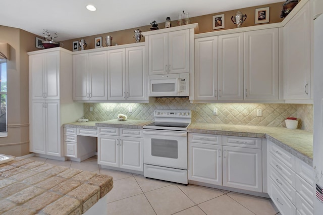 kitchen with white appliances, light countertops, white cabinetry, light tile patterned floors, and backsplash