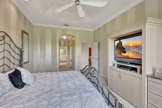 bedroom with arched walkways, carpet flooring, crown molding, wallpapered walls, and ceiling fan
