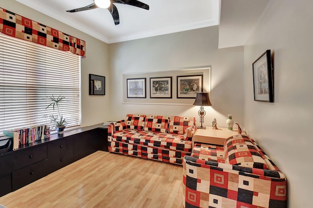 living area featuring wood finished floors, ceiling fan, and crown molding