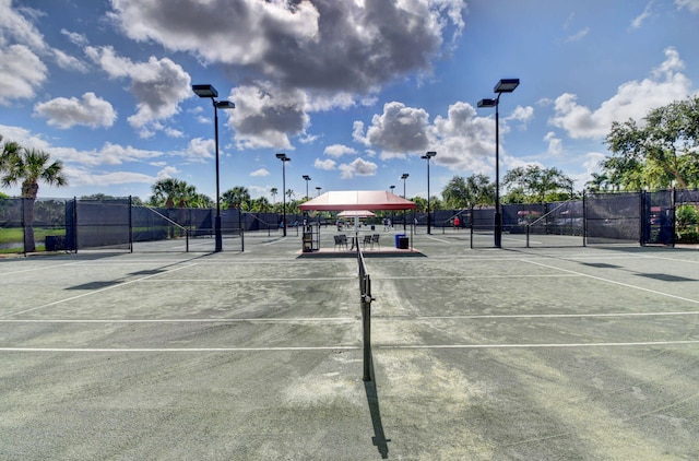 view of tennis court featuring fence