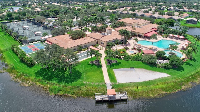 aerial perspective of suburban area with a nearby body of water and a pool