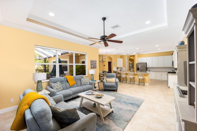 living area with a raised ceiling, arched walkways, ceiling fan, crown molding, and recessed lighting